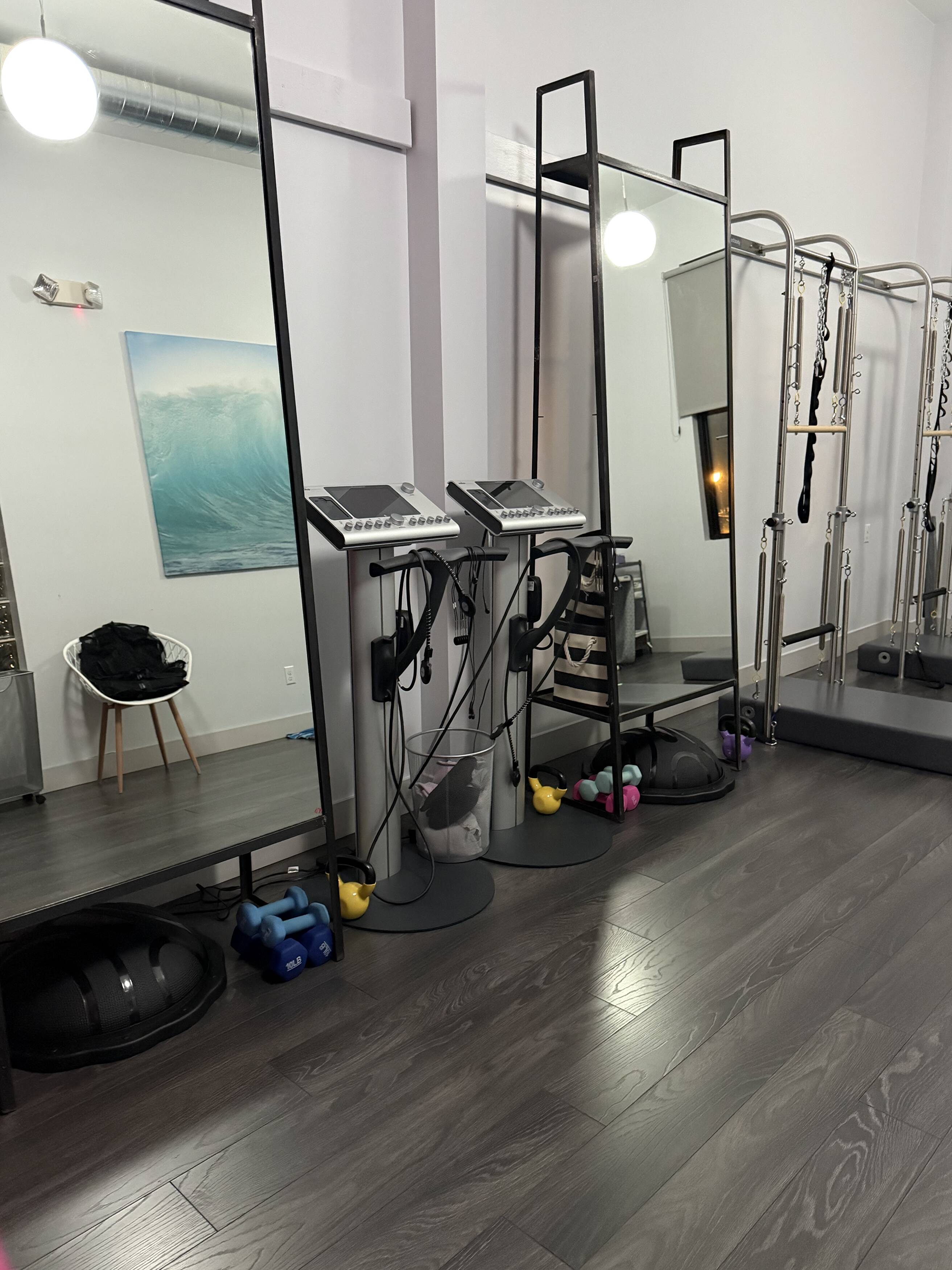 Electric Body EMS studio interior with EMS machines, mirrors, and colorful dumbbells